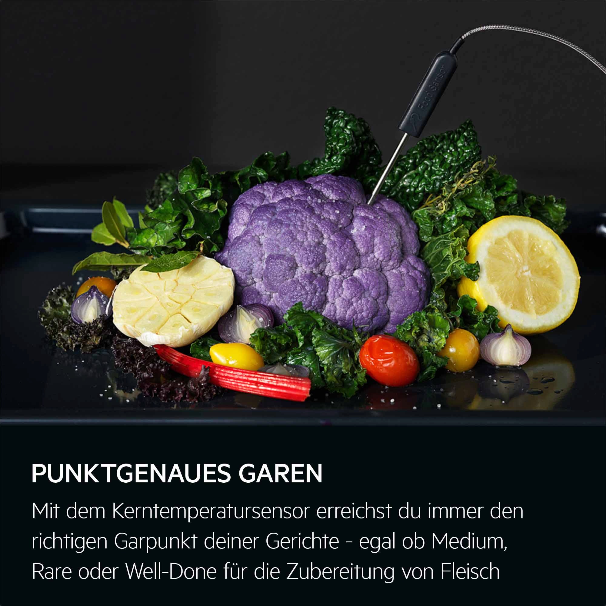 Kerntemperatursensor steckt in violettem Blumenkohl, umgeben von Gemüse und Zitronenscheibe.