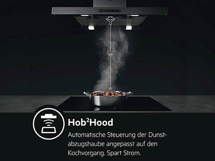 Automatisch gesteuerte Dunstabzugshaube über dampfendem Topf auf Kochfeld.